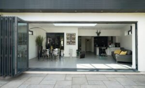 Stylish, open, bifold doors revealing interior of a designer, lifestyle, kitchen diner room.